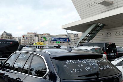 A taxi with a sign against then-French Economy Minister Emmanuel Macron as drivers demonstrate in Porte Maillot, on January 26, 2016 in Paris, France.