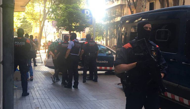 Police escort a suspect on Tamarit street in Barcelona.
