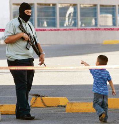 A child points at a policeman at a murder scene in the city in 2011.