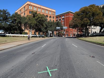 The X on the Dealey Plaza roadway in Dallas, Texas, marking the spot where Kennedy was hit by the third bullet. In the background, The Sixth Floor Museum, where the schoolbook depository from which Oswald shot the president was located in 1963.