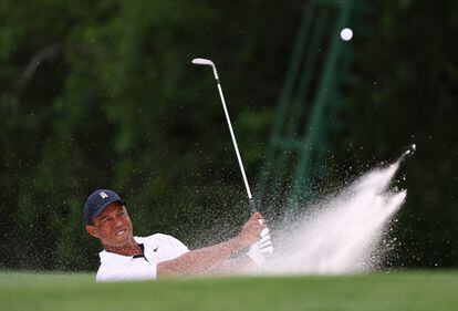 Tiger Woods of the U.S. plays out from a bunker on the 18th hole during the first round