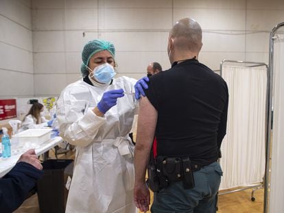 A health worker administering the AstraZeneca vaccine to a Civil Guard officer in a sports facility in Murcia.