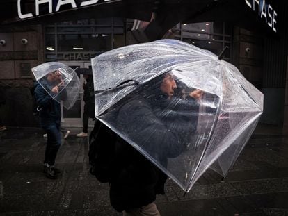 People walk through wind and rain during a nor'easter storm in Times Square in New York City, on April 3, 2024.