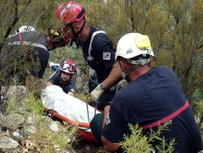 Firefighters salvage the body of V&iacute;ctor Cabedo from the mountainside last week.