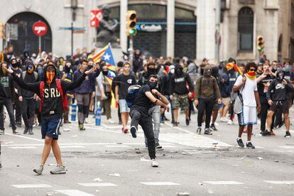 Masked protestors hurl objects at police in Via Laietana, Barcelona on Friday afternoon.