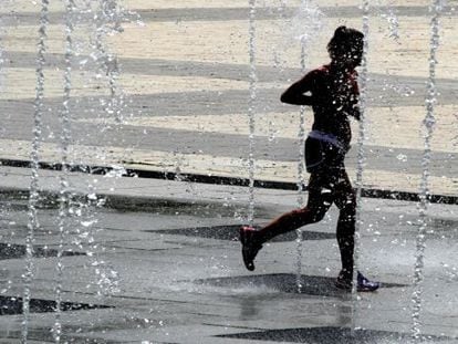 A woman runs through some fountains in Madrid’s Juan Carlos I park on Wednesday.