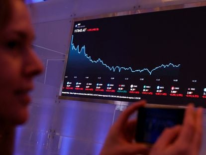 A woman in front of a screen, which shows the evolution of the São Paulo Stock Exchange, on Thursday, July 6, 2023