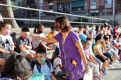 A teacher takes children's temperature at Rafael Casanova school in  Badalona, in Catalonia.