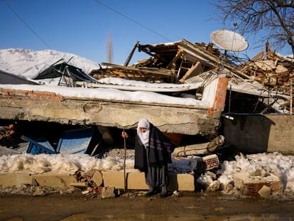 Zehra Kurukafa walks past a destroyed house in the village of Polat, Turkey, Sunday, Feb. 12, 2023.