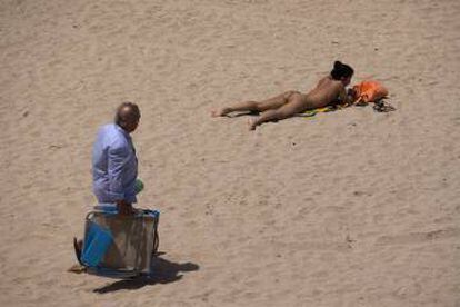 A young woman topless on Victoria beach, Cádiz.
