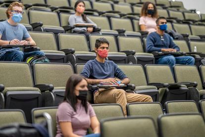 College students sitting in a lecture hall keeping social distance during the COVID-19 pandemic