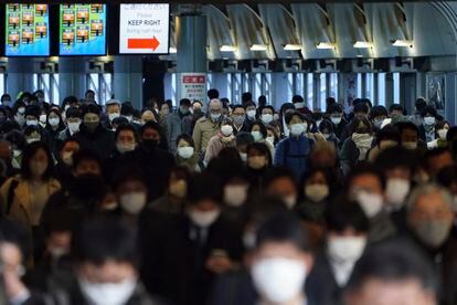 A station passageway is crowded with commuters wearing face mask during a rush hour on January 8, 2021, in Tokyo.