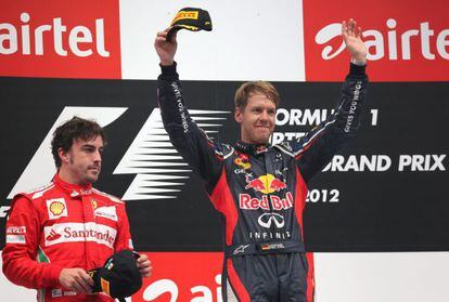 Sebastian Vettel (R) of Red Bull Racing celebrates on the podium after he won the India Grand Prix ahead of Fernando Alonso (L).