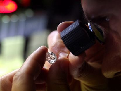 An employee looks at a rough diamond at Flanders Manufacturing, as the G7 weighs a ban on Russian diamond imports, Antwerp, Belgium, October 30, 2023.