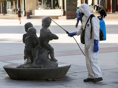 A cleaner disinfects a statue at Pilar square in Zaragoza.