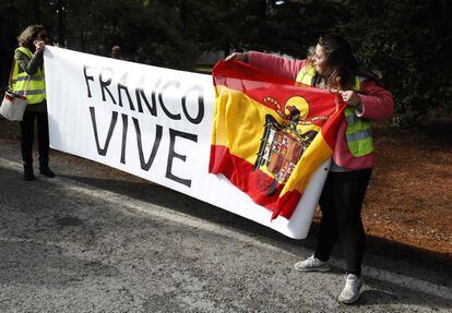 Franco supporters hold a banner with the message “Franco lives” and a pre-constitutional Spanish flag.