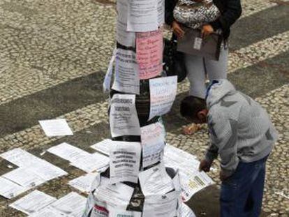 Two people read job postings on a street in São Paulo, Brazil.