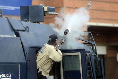 A law enforcement officer fires tear gas during a protest in Caracas.