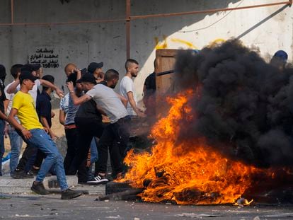 Palestinian demonstrators clash with the Israeli army while forces carry out an operation in the West Bank town of Nablus, Tuesday, Aug. 9, 2022.
