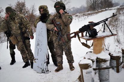 Ukrainian soldiers pose next to the remains of a missile they claim to have shot down with the machine gun. 