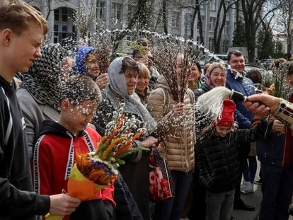An Orthodox priest sprays holy water on believers after a service which marks the Orthodox feast of Palm Sunday, amid Russia's invasion of Ukraine, in Kyiv, Ukraine April 9, 2023