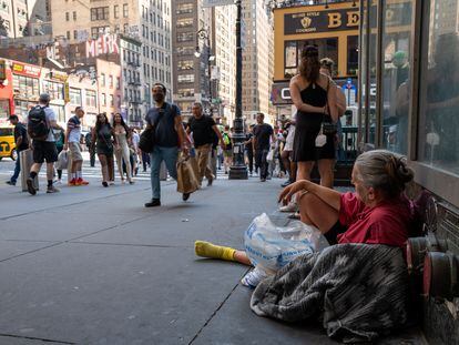 A homeless woman rests on a Manhattan street during a heat wave on July 22, 2022.