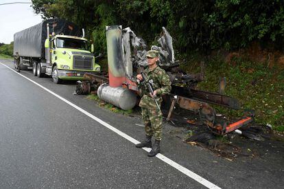 A soldier stands guard next to a truck burned by members of the Clan del Golfo cartel in Antioquia, Colombia, on May 6, 2022.