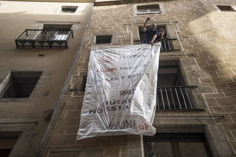 Activists unfurl a banner protesting against illegally let apartments.