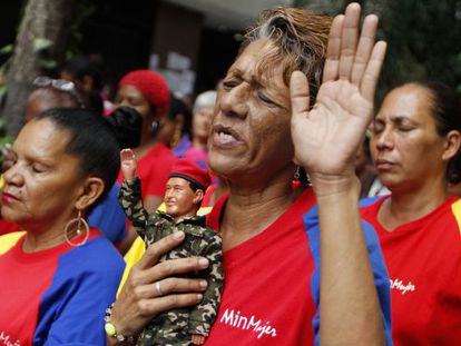A woman holds a figurine of Ch&aacute;vez as she prays for his health in Caracas on Tuesday