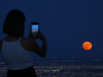 A woman photographs the supermoon over Juárez (Mexico), on August 30th.