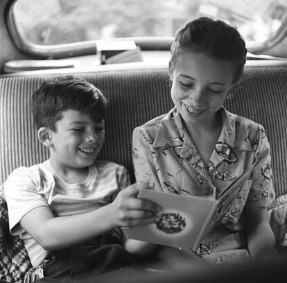 Two children read a book in the back seat of a car, in an image taken in Williamsburg, Virginia, in 1949.
