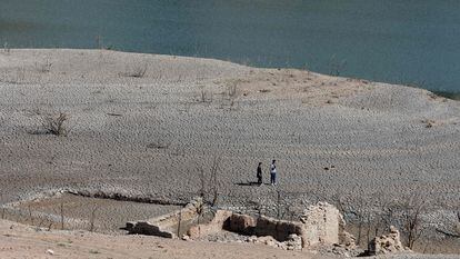 Two people walk through the Sau reservoir, in Girona, on April 16, 2023.