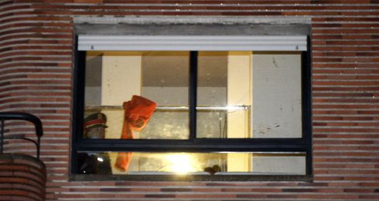 Police search the home where the dead body was found.