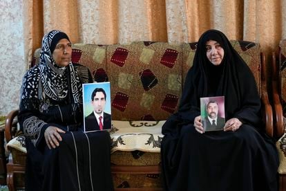 Nidal Ali, right, and Nawal Sweidan hold photos of their missing sons in Mahmoudiya, south of Baghdad, Iraq, Tuesday, March 28, 2023