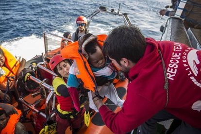 A baby is loaded into the rescue vessel of the Spanish NGO Proactiva Open Arms on December 21