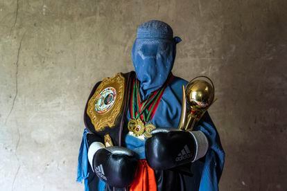 An Afghan mixed martial arts fighter poses with her trophies in Kabul. Beatings from parents and ridicule from neighbors were not enough to intimidate these athletes, who wanted to practice the sport they loved. After the arrival of the Taliban, they say they are not the same people.