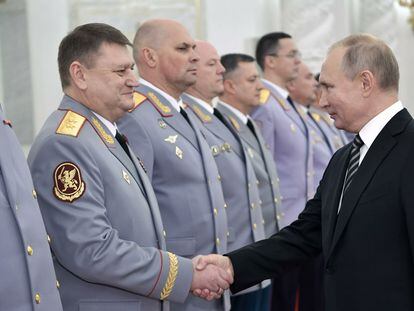 Russian President Vladimir Putin greets the new head of logistics for the Russian army, Alexey Kuzmenkov, in a photo released by the Kremlin.