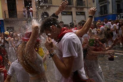 Revelers cool off with water thrown from balconies during the 'Chupinazo' rocket, which marks the official opening of the 2023 San Fermín fiestas in Pamplona.