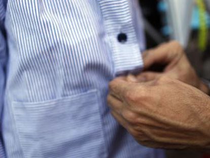 A father buttons up his son’s smock before taking him to school in Madrid.