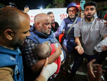 Al Jazeera's correspondent in Gaza, Wael Dahdouh, holds in his arms the body of one of his sons, killed with his wife and daughter in an Israeli bombing, at the al-Aqsa hospital in the south of the Strip, on October 25, 2023.