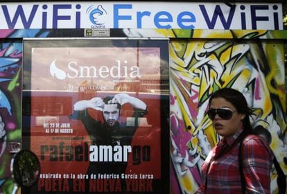 A woman walks past a newspaper kiosk joined to the Gowex wi-fi network in Madrid.