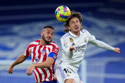 Real Madrid's Luka Modric, right, heads the ball past Atletico Madrid's Koke during a Spanish La Liga soccer match between Real Madrid and Atletico Madrid at the Santiago Bernabeu stadium in Madrid, Spain, Saturday, Feb. 25, 2023.