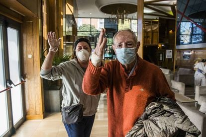 After being discharged, Francisco Javier Jiménez, 86, says goodbye to the health workers in the lobby of La Paz’s converted hotel-hospital, along with his daughter Aurora, who has come to pick him up. 