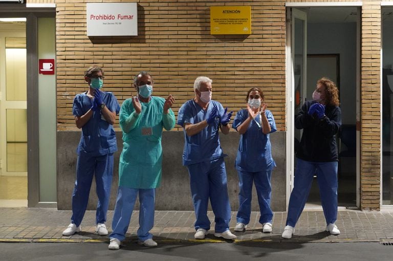 Health workers at a hospital in Seville applaud outside the emergency ward.