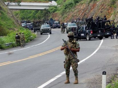 Soliders stand guard on a highway near the town of Arteaga, Michoac&aacute;n state, where 22 killings were reported Tuesday. 