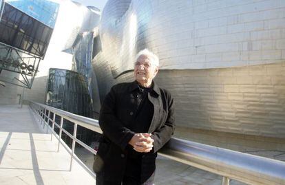 Frank Gehry standing in front of the Guggenheim Museum in Bilbao.