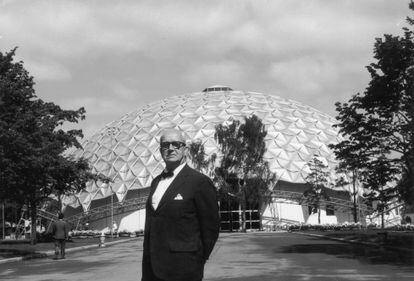 Buckminster Fuller poses next to the geodesic dome with a gold-anodized aluminum roof he designed for the American National Exhibition in Moscow. 