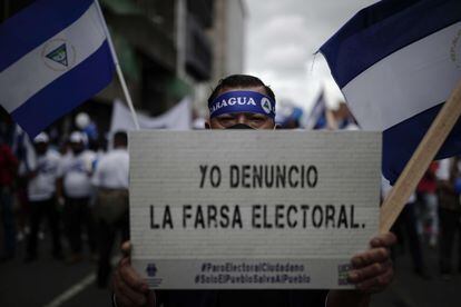 A protester at a demonstration against the results of the 2021 Nicaraguan election holds up a sign reading: “I denounce electoral fraud.”