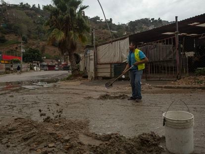 José Guzmán cleans up mud in the streets of Los Laureles in Tijuana after a night of rain; November 15, 2023.