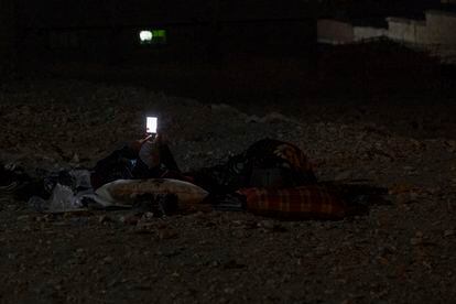 A resident of Mulay Brahim makes a video call while lying on the street,